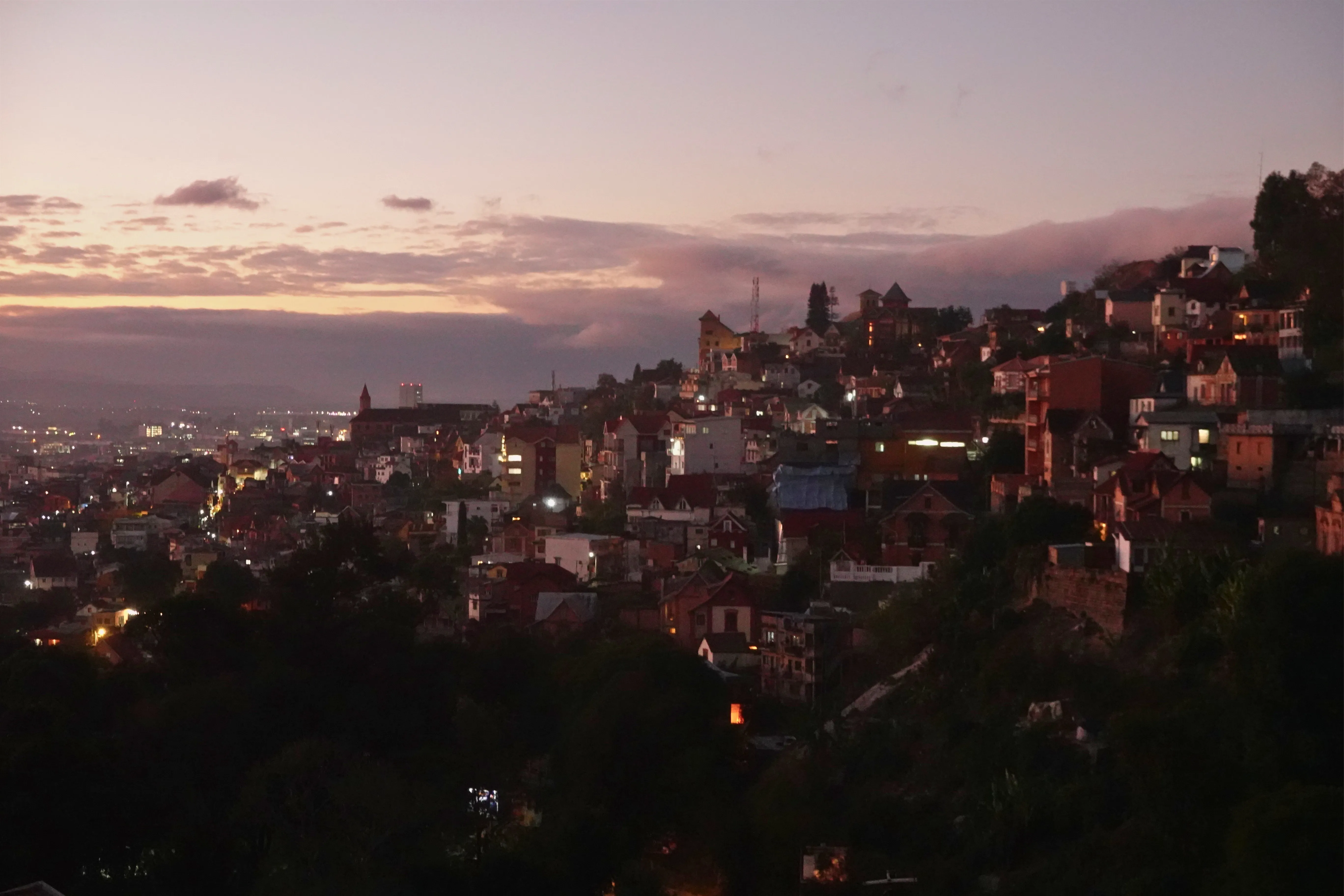 Ville en pente illuminée au coucher de soleil sur Madagascar avec architecture colorée et vue panoramique