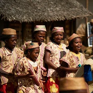 Groupe de danseuses malgaches en tenues traditionnelles colorées souriantes lors d'une cérémonie