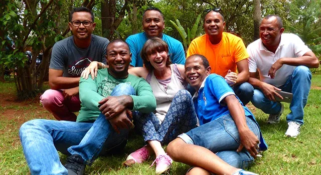 Groupe joyeux en tenue décontractée posant souriants dans un cadre naturel verdoyant