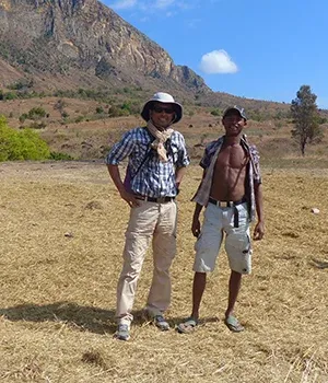Deux voyageurs posant devant des paysages montagneux secs et verdoyants à Madagascar