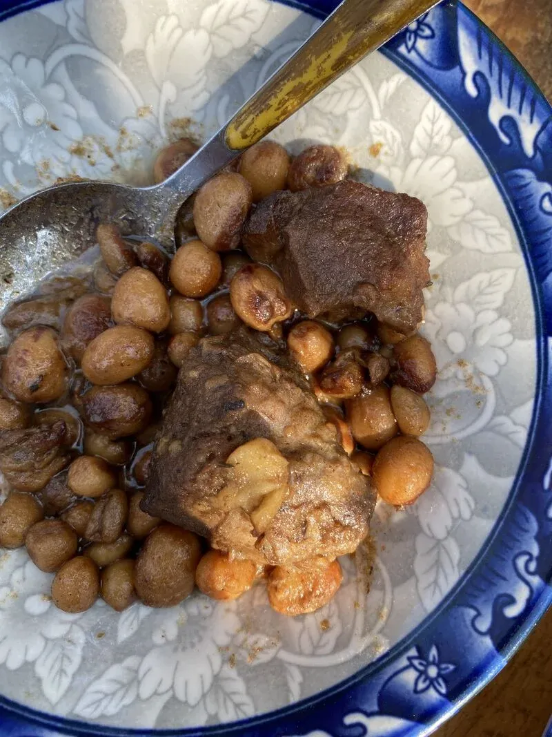 Assiette traditionnelle malgache avec viande grillée et pommes de terre rôties dans un plat coloré