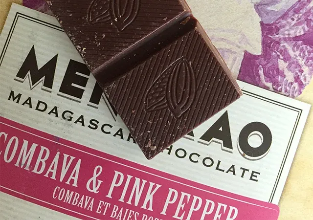 Tablette chocolat Madagascar Menaka au combava et poivre rose posée sur son emballage coloré