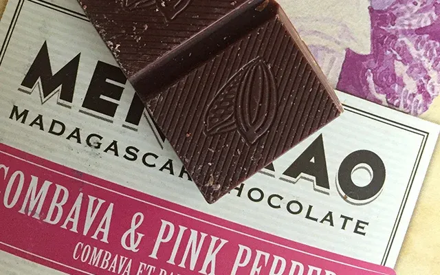 Tablette chocolat Madagascar Combava et poivre rose Menaka posée sur son emballage coloré