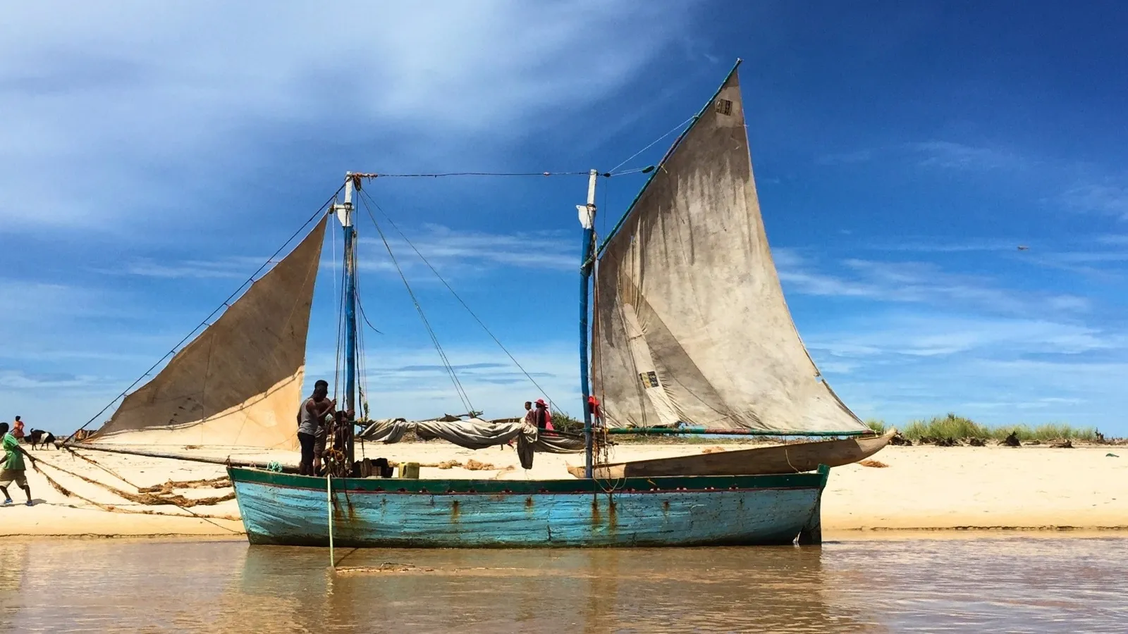 Bateau traditionnel madagascar pirogue à voile sur plage avec pêcheurs en activité