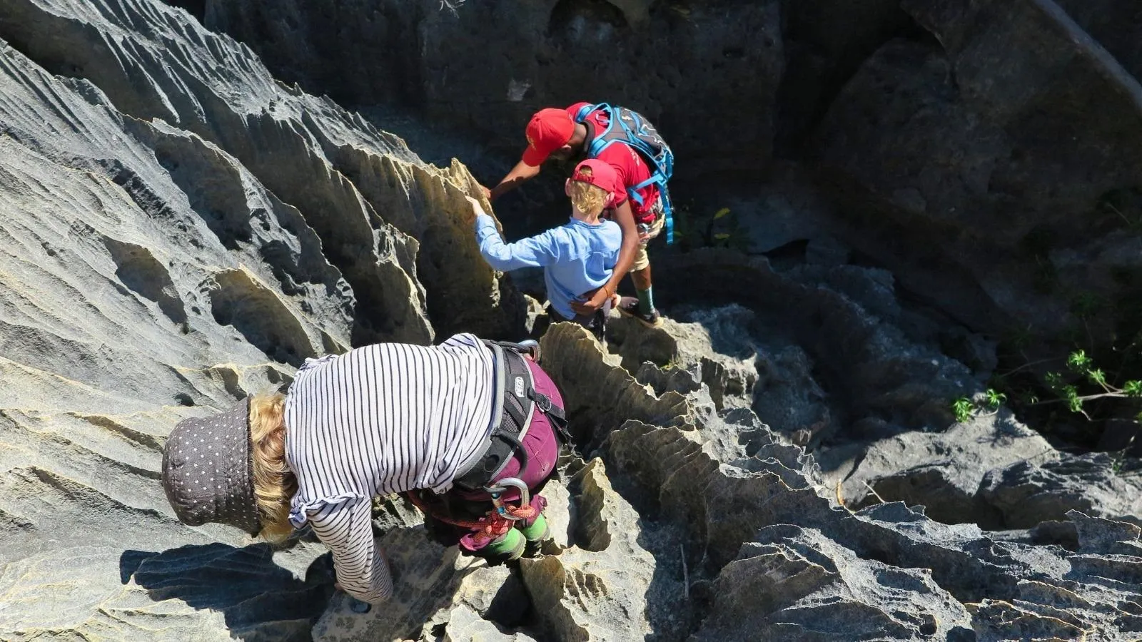 Randonnée en famille sur des rochers escarpés à Madagascar avec équipements de sécurité