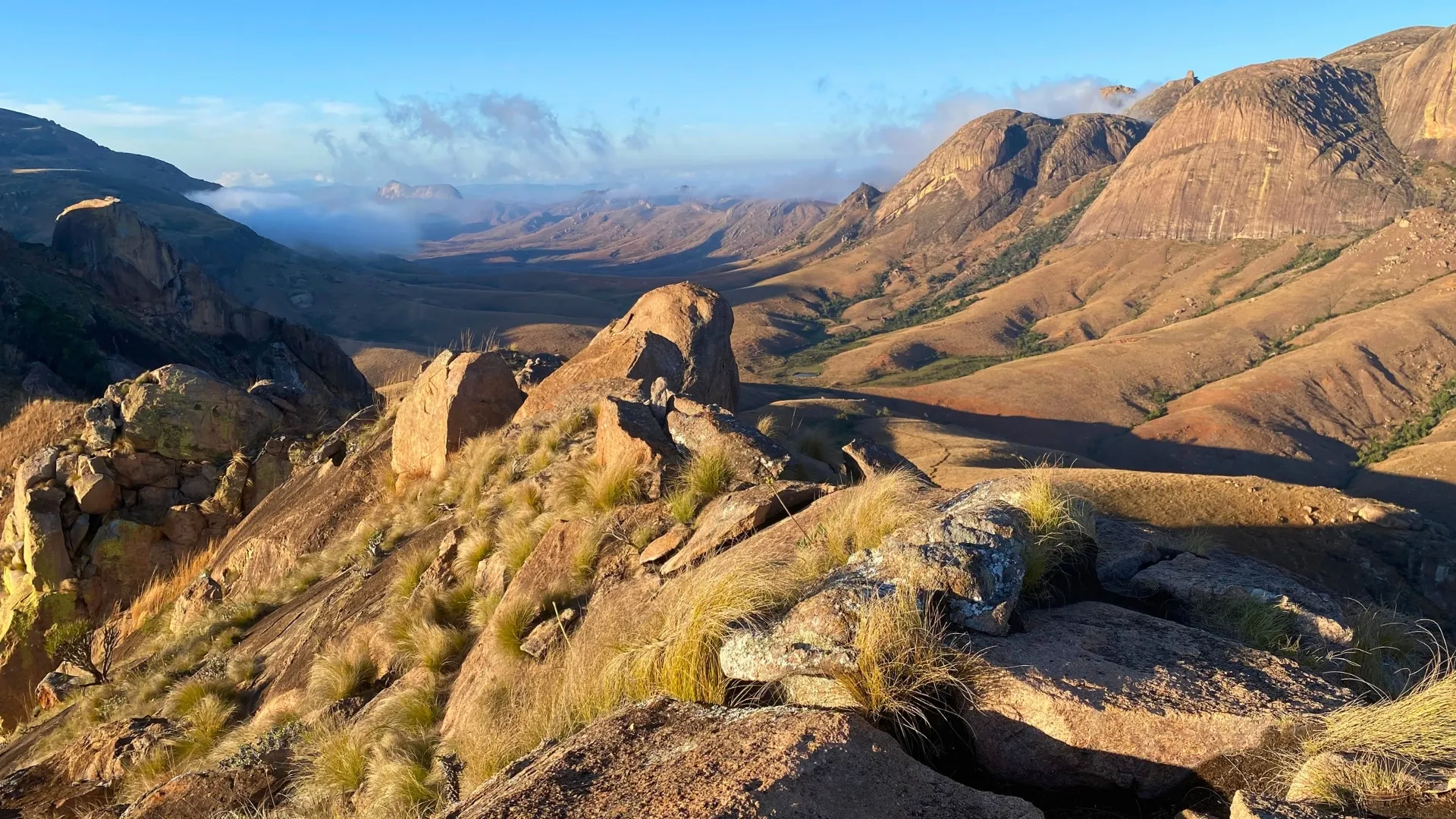 Paysages montagneux arides de Madagascar baignés par une lumière dorée au coucher du soleil