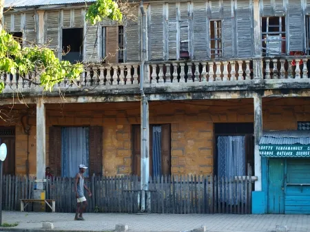 Façade de maisons avec un homme marchant sur le trottoir.